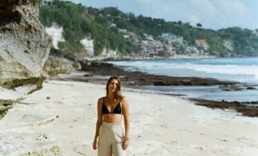 a woman standing on top of a sandy beach