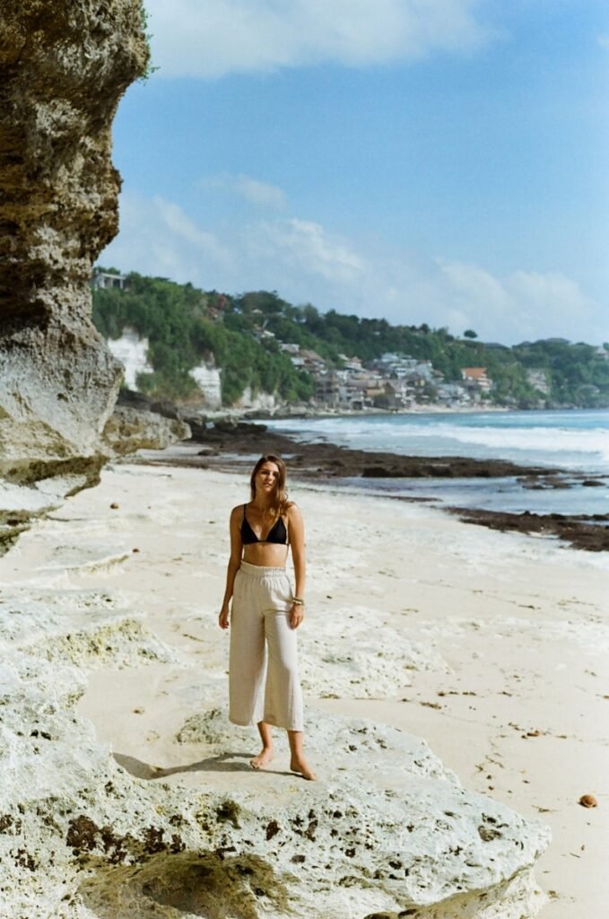 a woman standing on top of a sandy beach